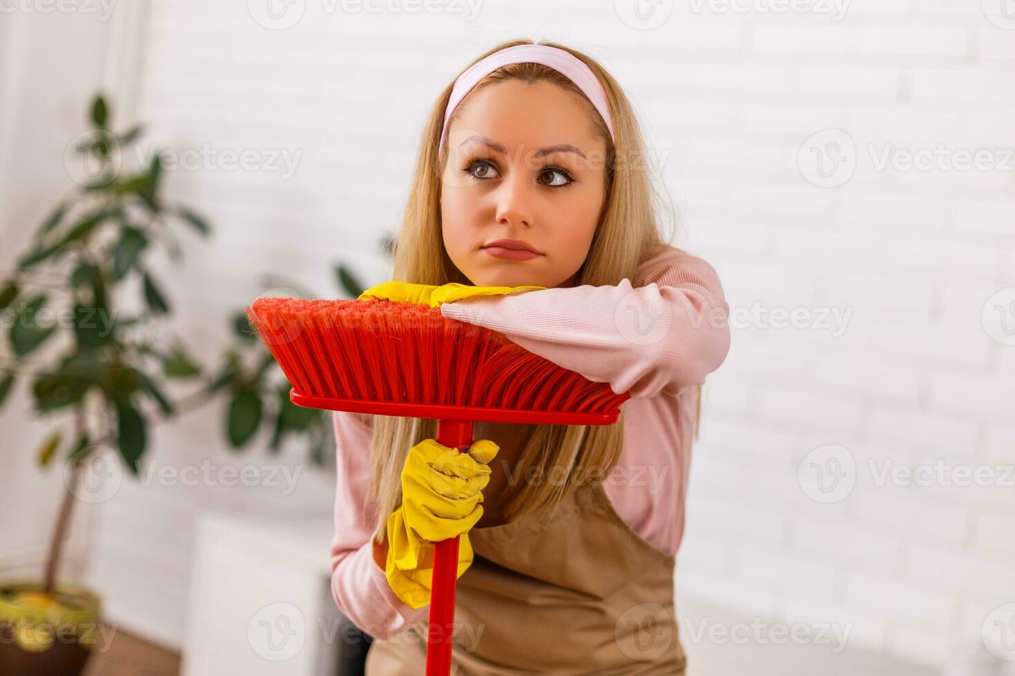 fatigué femme au foyer nettoyage vivant pièce avec une balai. photo