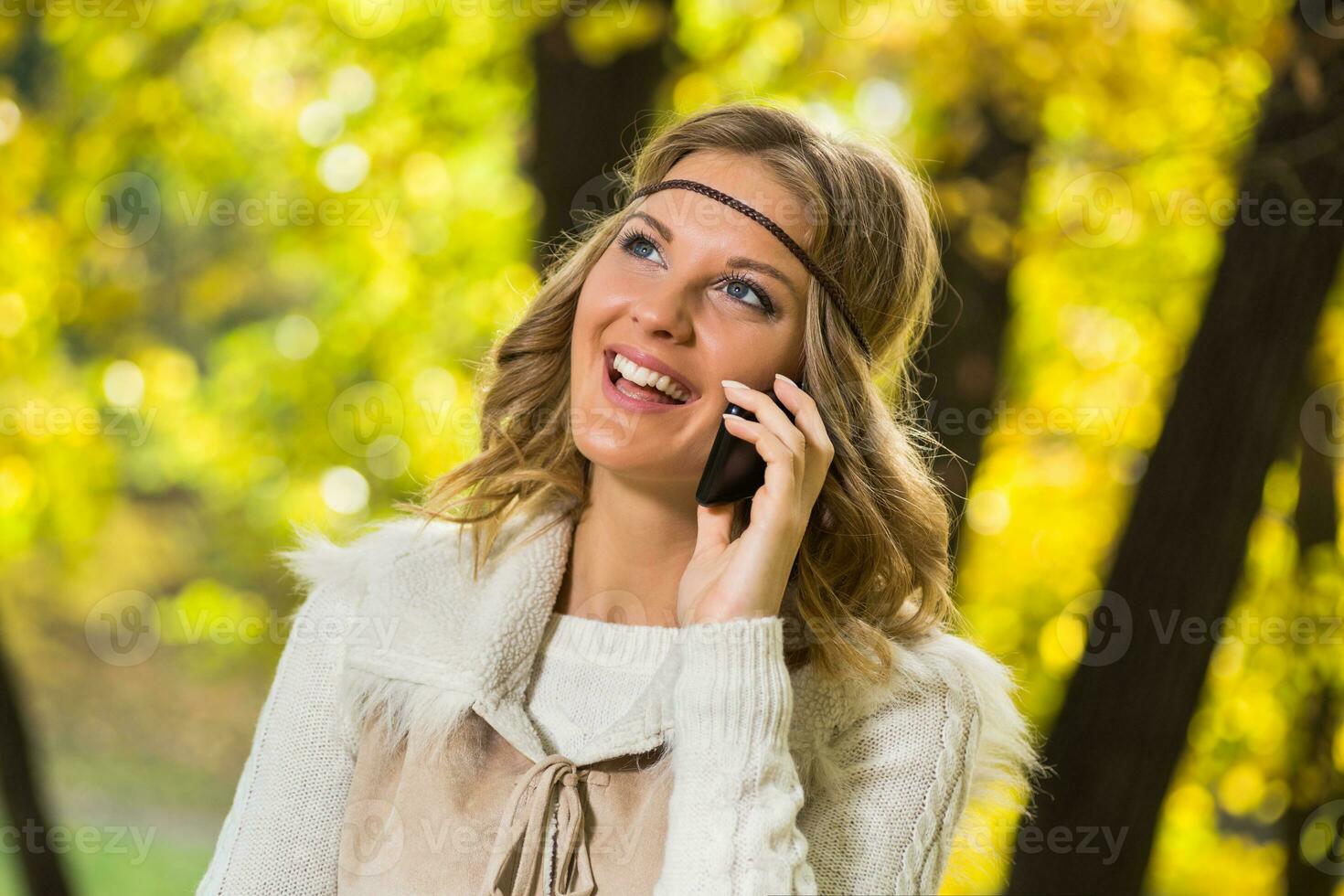 magnifique boho fille jouit parlant sur le téléphone dans le parc. photo