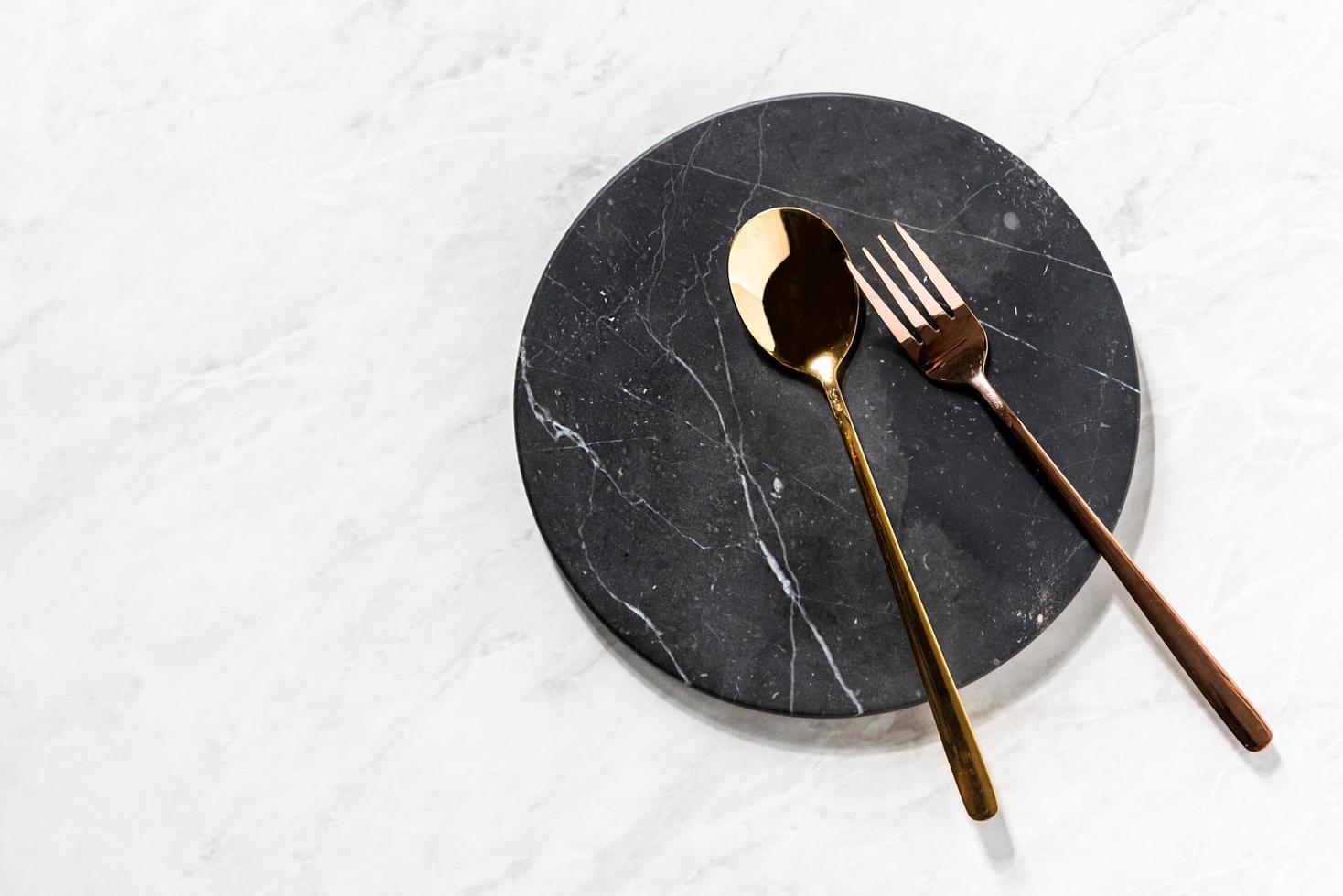 fourchette et cuillère sur un plateau en marbre noir photo