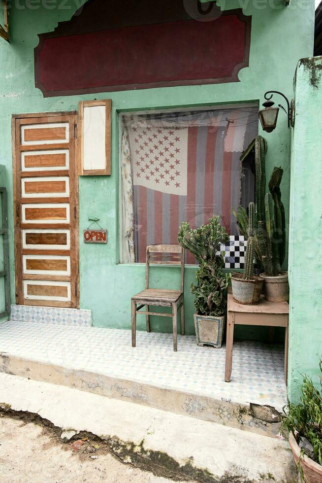 vieux chaise et cactus près de face porte de petit ancien pays magasin. photo