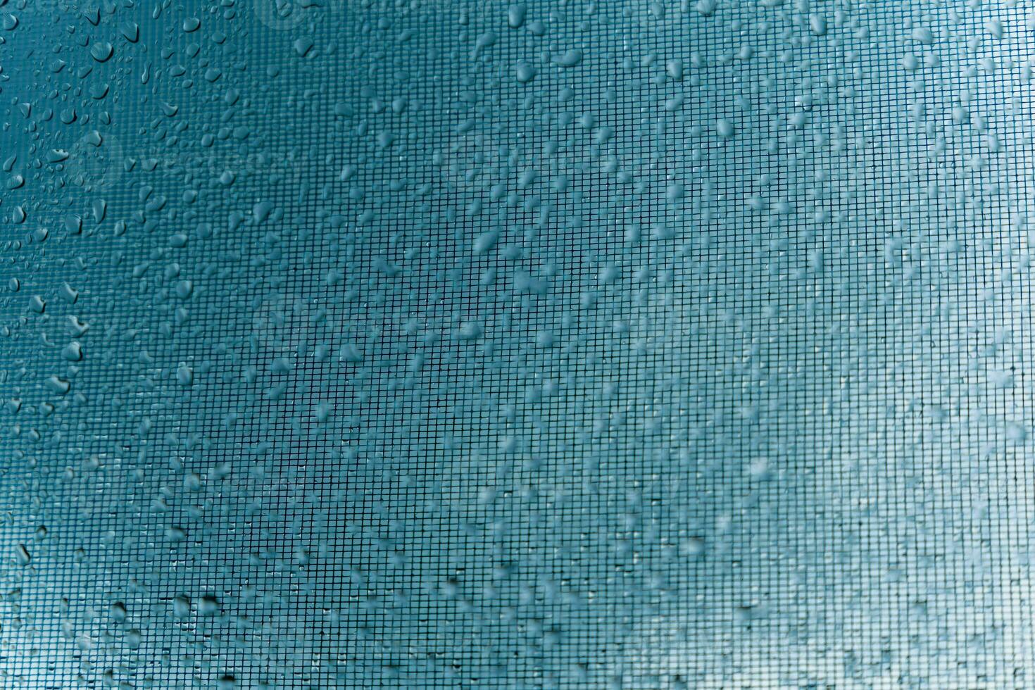 fermer de gouttes de pluie sur une fenêtre verre avec flou ville lumières reflétant dans le Contexte photo