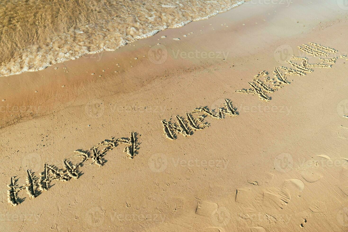 content Nouveau année une inscription sur sablonneux plage avec océan vagues dans tropical paradis photo