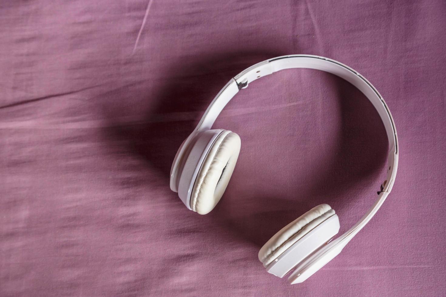 écouteurs blancs sur fond violet. notion de musique. photo