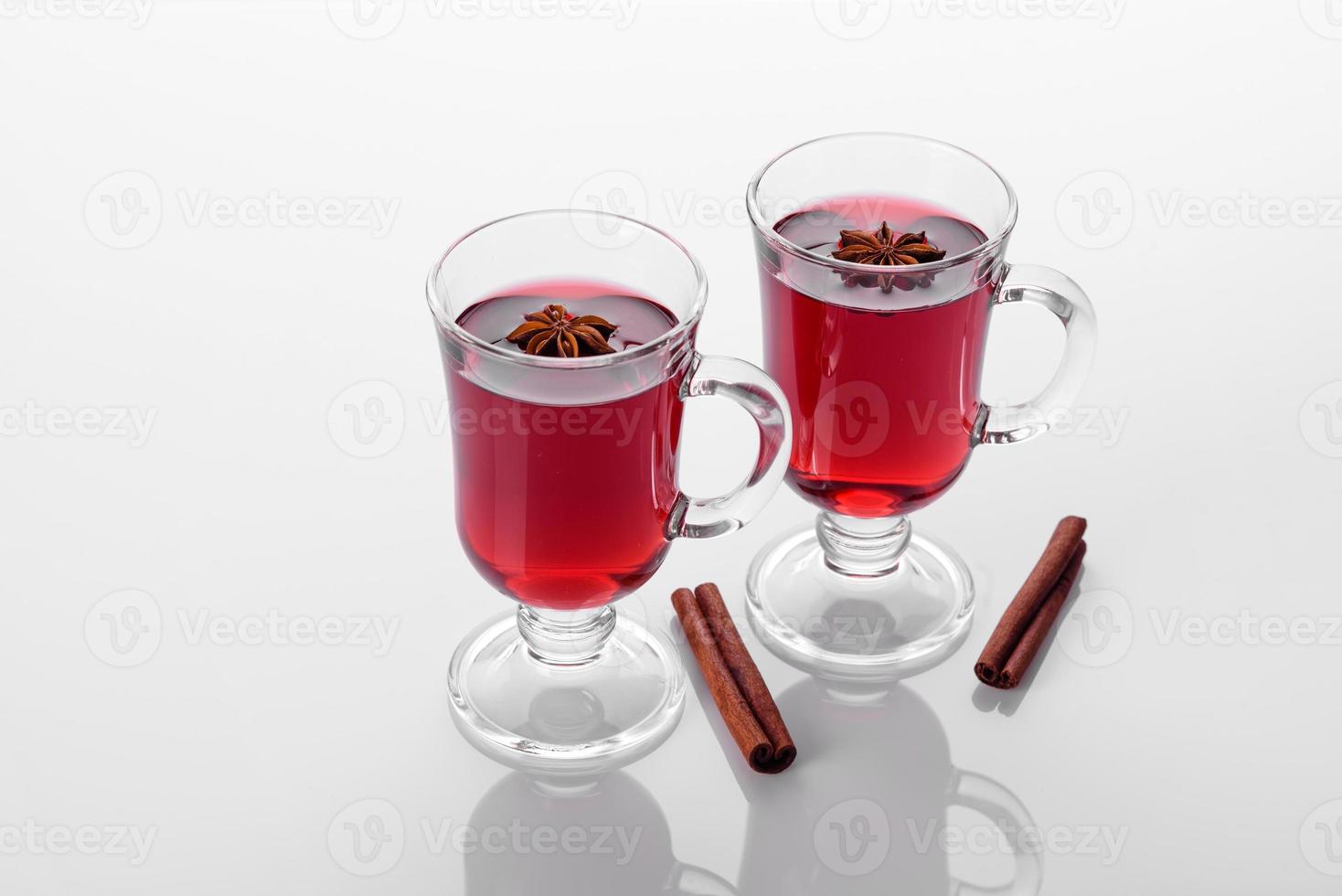 Vin chaud rouge isolé sur fond blanc avec des épices de Noël photo