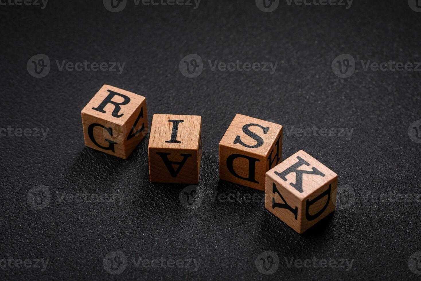 le une inscription risque avec en bois cubes sur une foncé béton Contexte photo