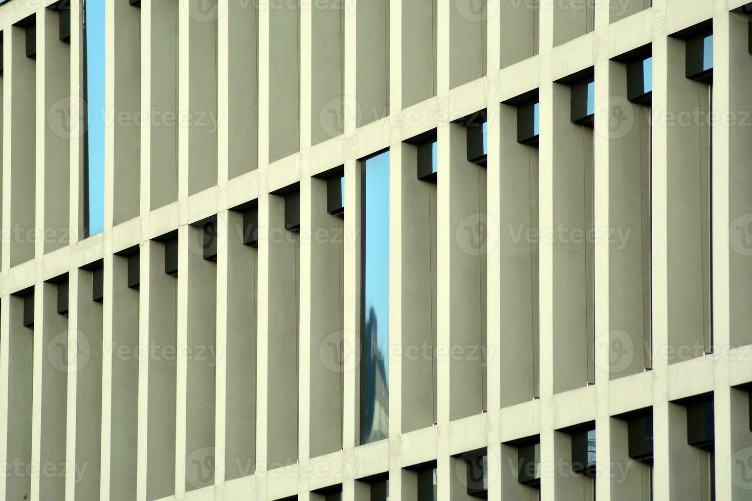 moderne Bureau bâtiment dans le ville avec les fenêtres et acier et aluminium panneaux mur. contemporain commercial architecture, verticale convergent géométrique lignes. photo