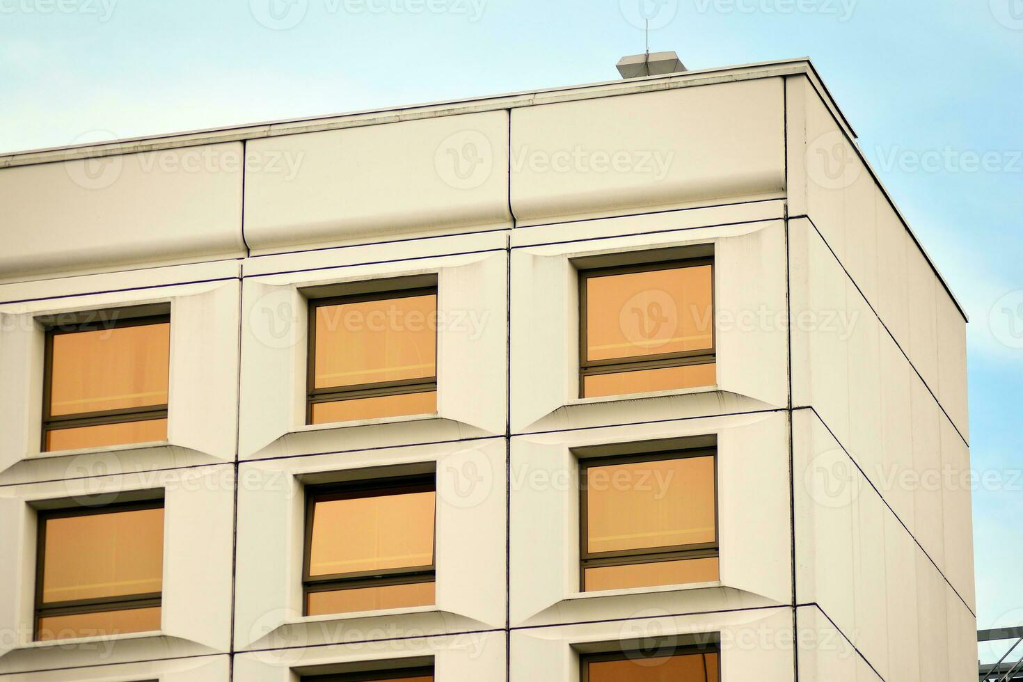 moderne Bureau bâtiment dans le ville avec les fenêtres et acier et aluminium panneaux mur. contemporain commercial architecture, verticale convergent géométrique lignes. photo