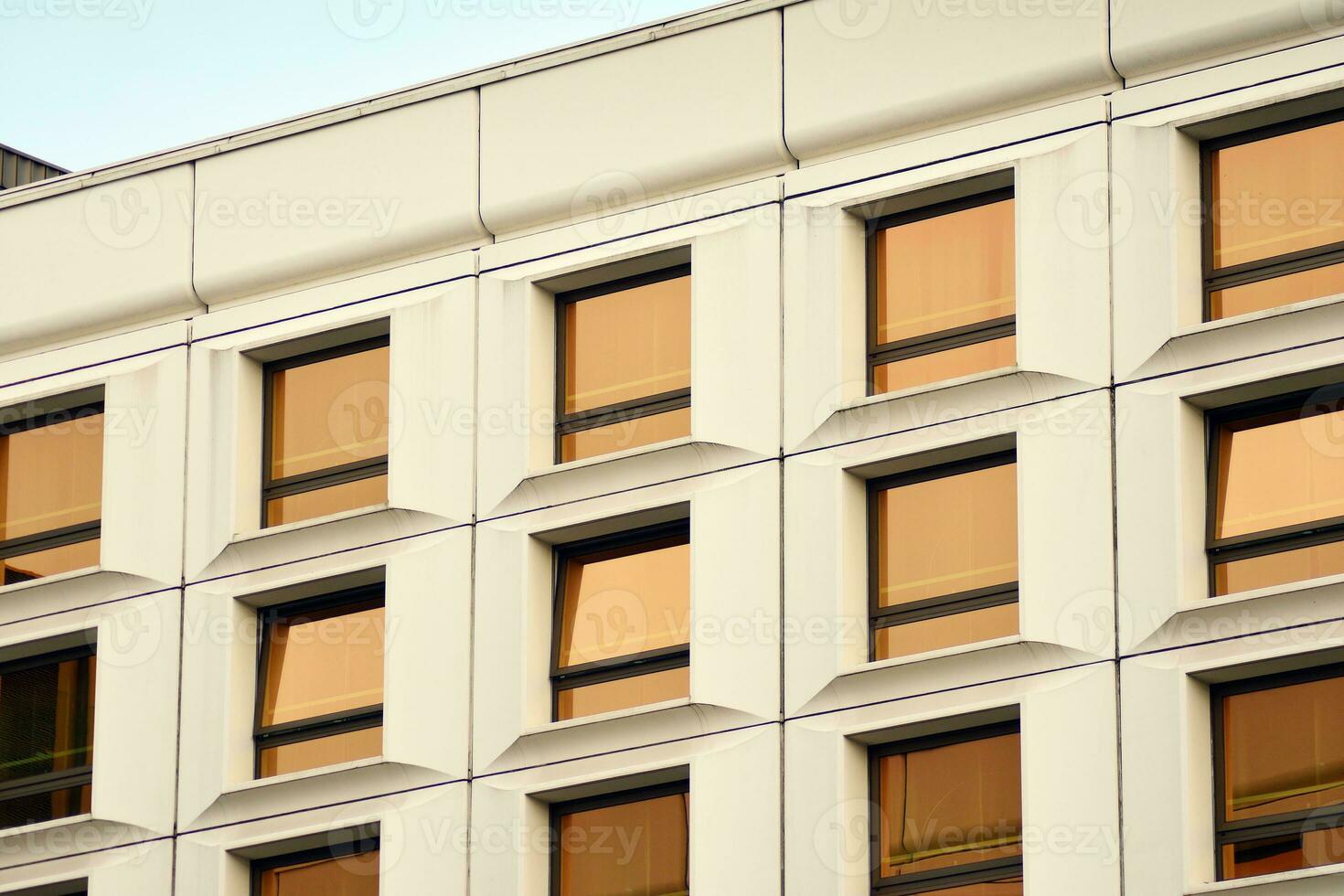 moderne Bureau bâtiment dans le ville avec les fenêtres et acier et aluminium panneaux mur. contemporain commercial architecture, verticale convergent géométrique lignes. photo