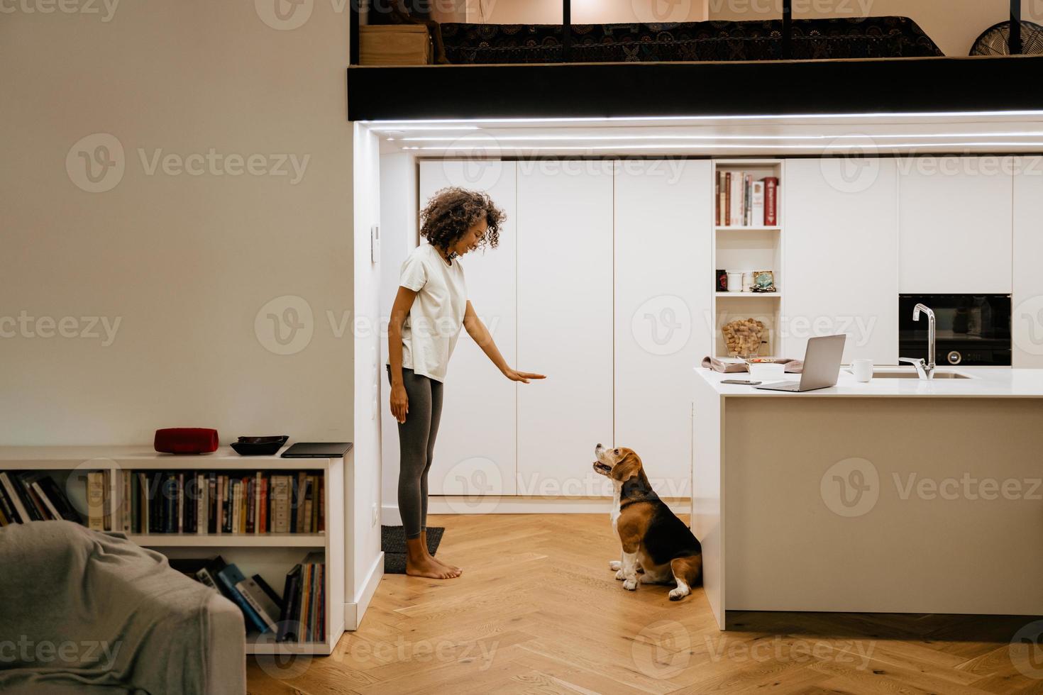 jeune femme noire souriante en jouant avec son chien photo