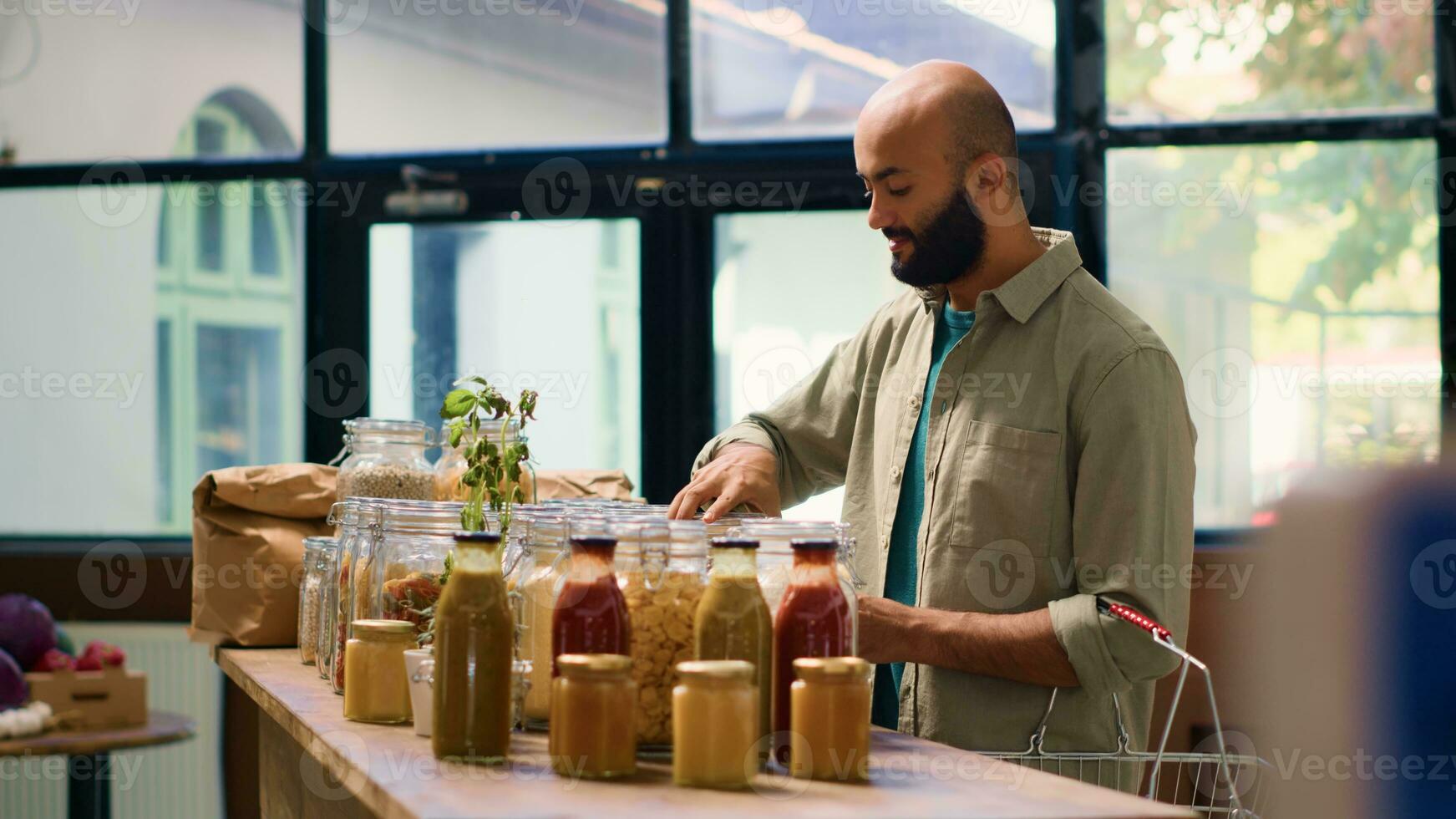 Jeune adulte ouvre épices pot à odeur Frais aromatique des produits, achat herbes et garde-manger Provisions pour durable mode de vie et en bonne santé alimentaire. milieu est homme à la recherche à céréales. ordinateur de poche tir. photo