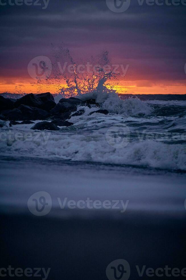 vague s'écraser à le Roche péché le coucher du soleil photo