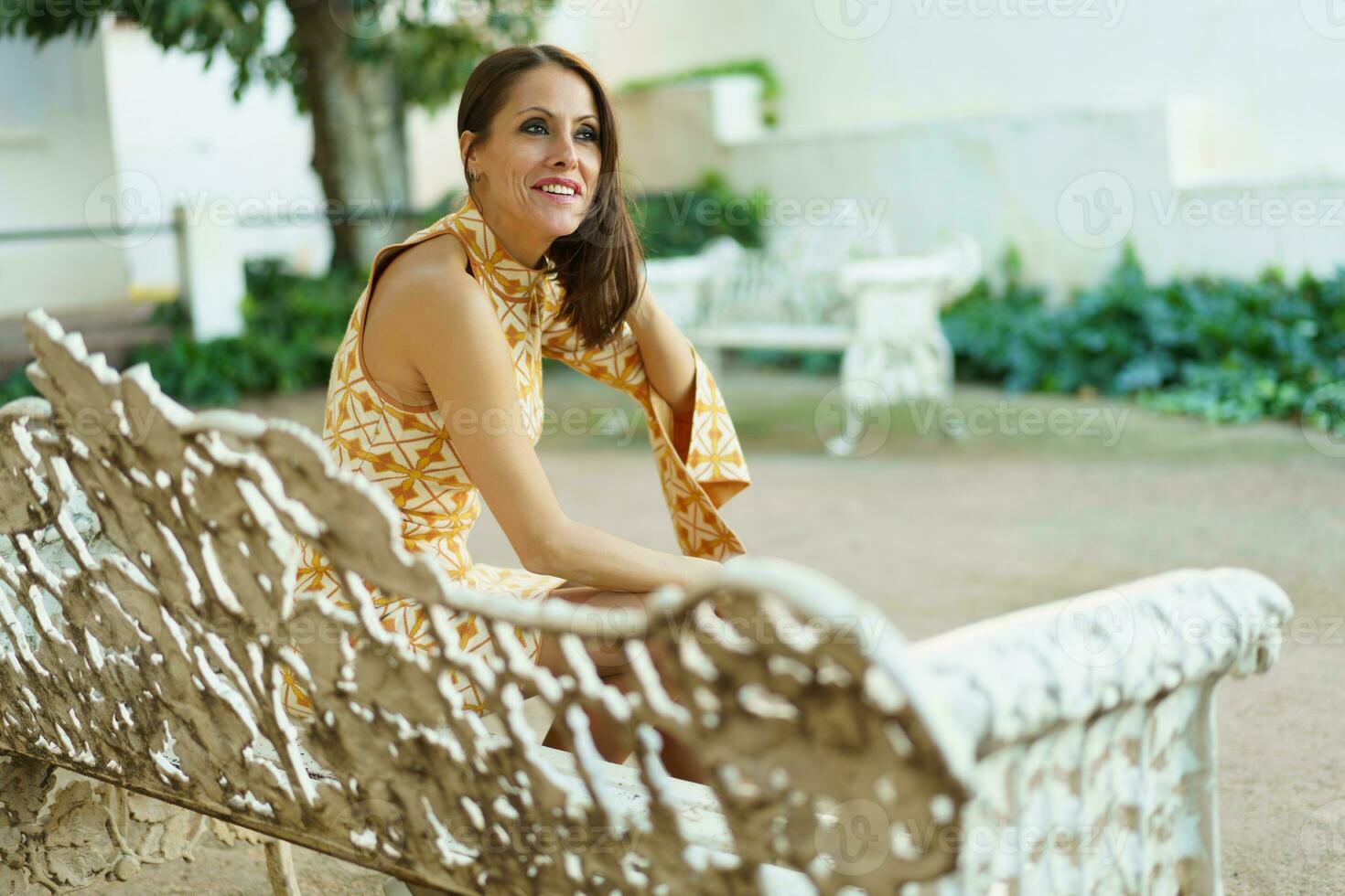 concentré Jeune femme séance sur blanc banc dans parc photo