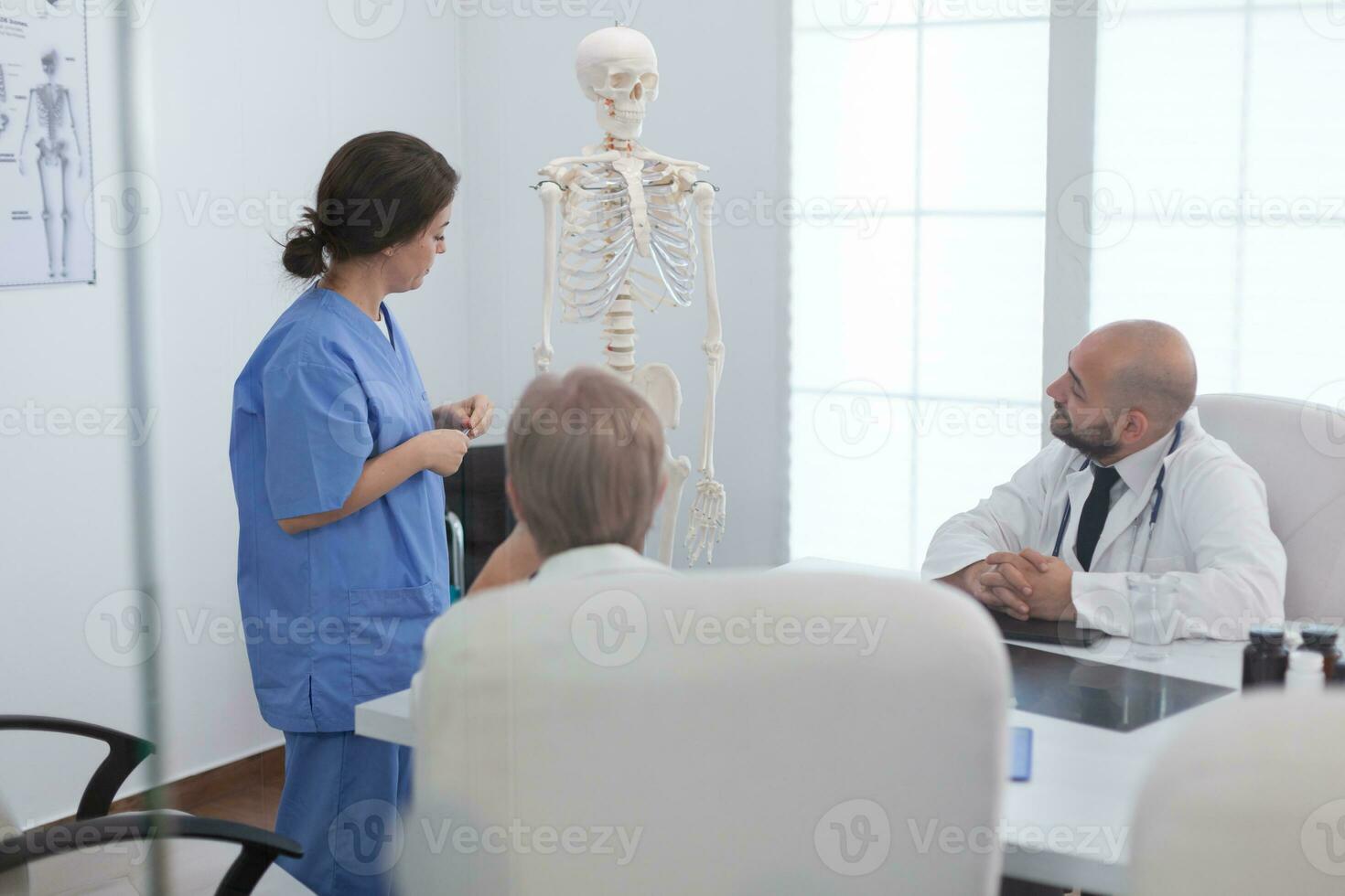 médical femme infirmière expliquant Humain corps structure en utilisant anatomie OS squelette en présentant recherche diagnostic discuter maladie traitement. hôpital équipe travail dans conférence réunion pièce photo