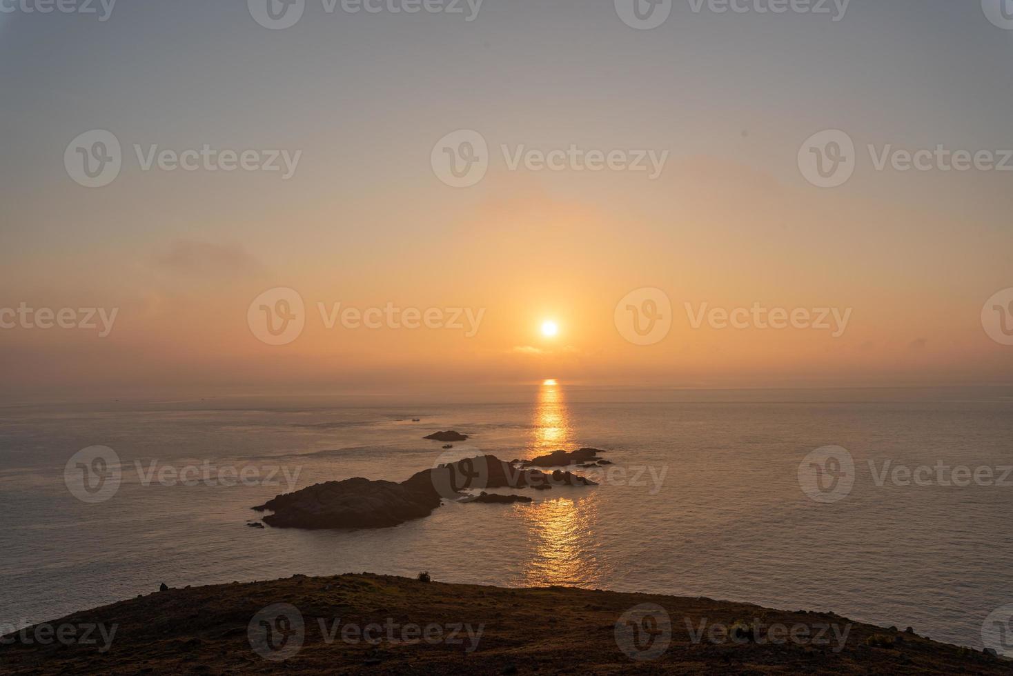 le soleil se lève d'une île dans l'océan photo