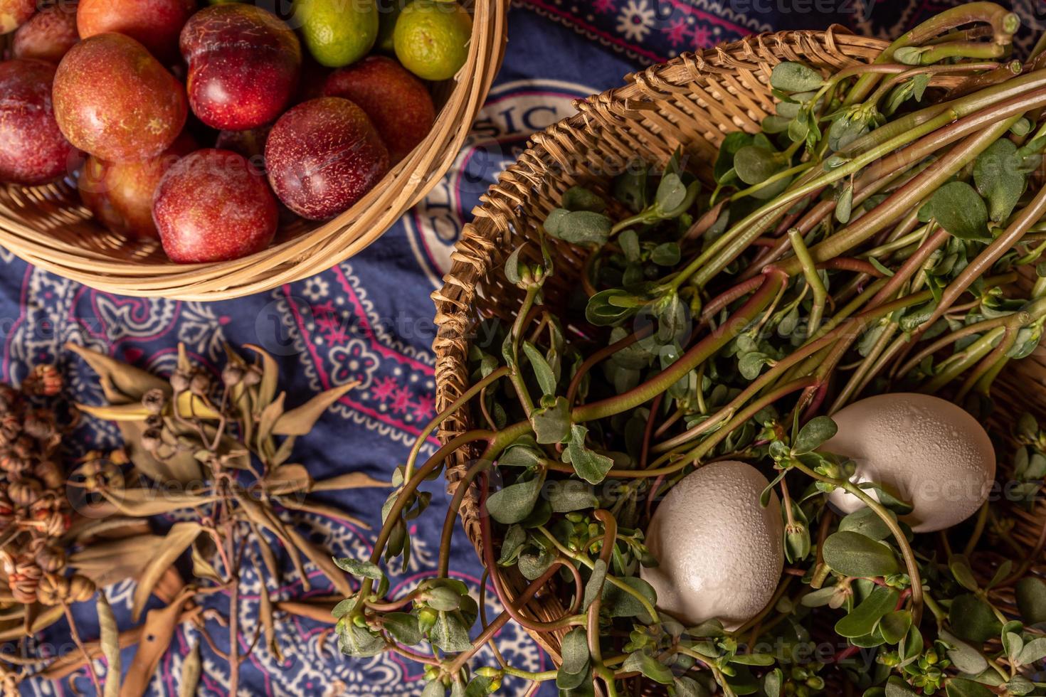 les œufs et autres fruits et légumes du panier sont sur la table à grain de bois photo