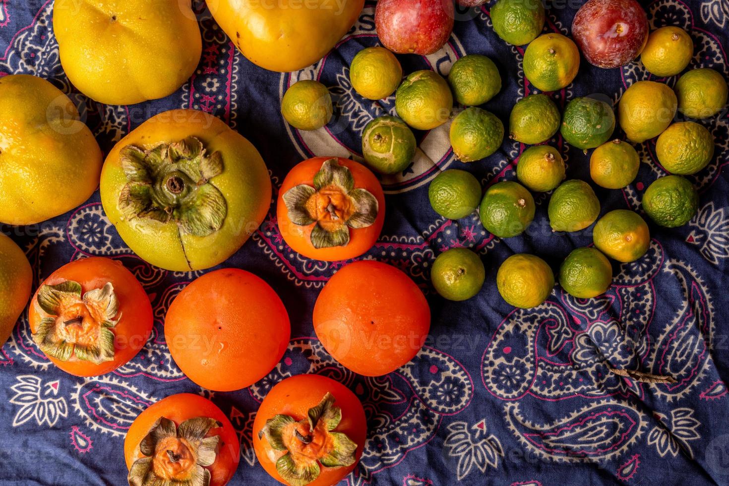 de nombreuses couleurs et variétés de fruits sont soit dans l'assiette, soit dispersées sur la table en bois photo