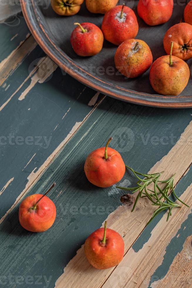 aubépine rouge sur une assiette ou éparpillée sur une table en bois photo