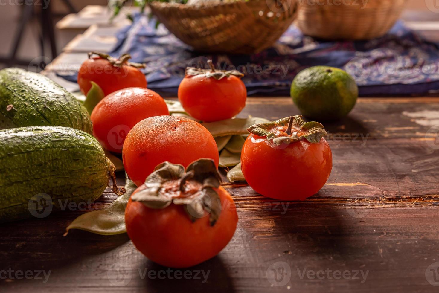 de nombreuses couleurs et variétés de fruits sont soit dans l'assiette, soit dispersées sur la table en bois photo