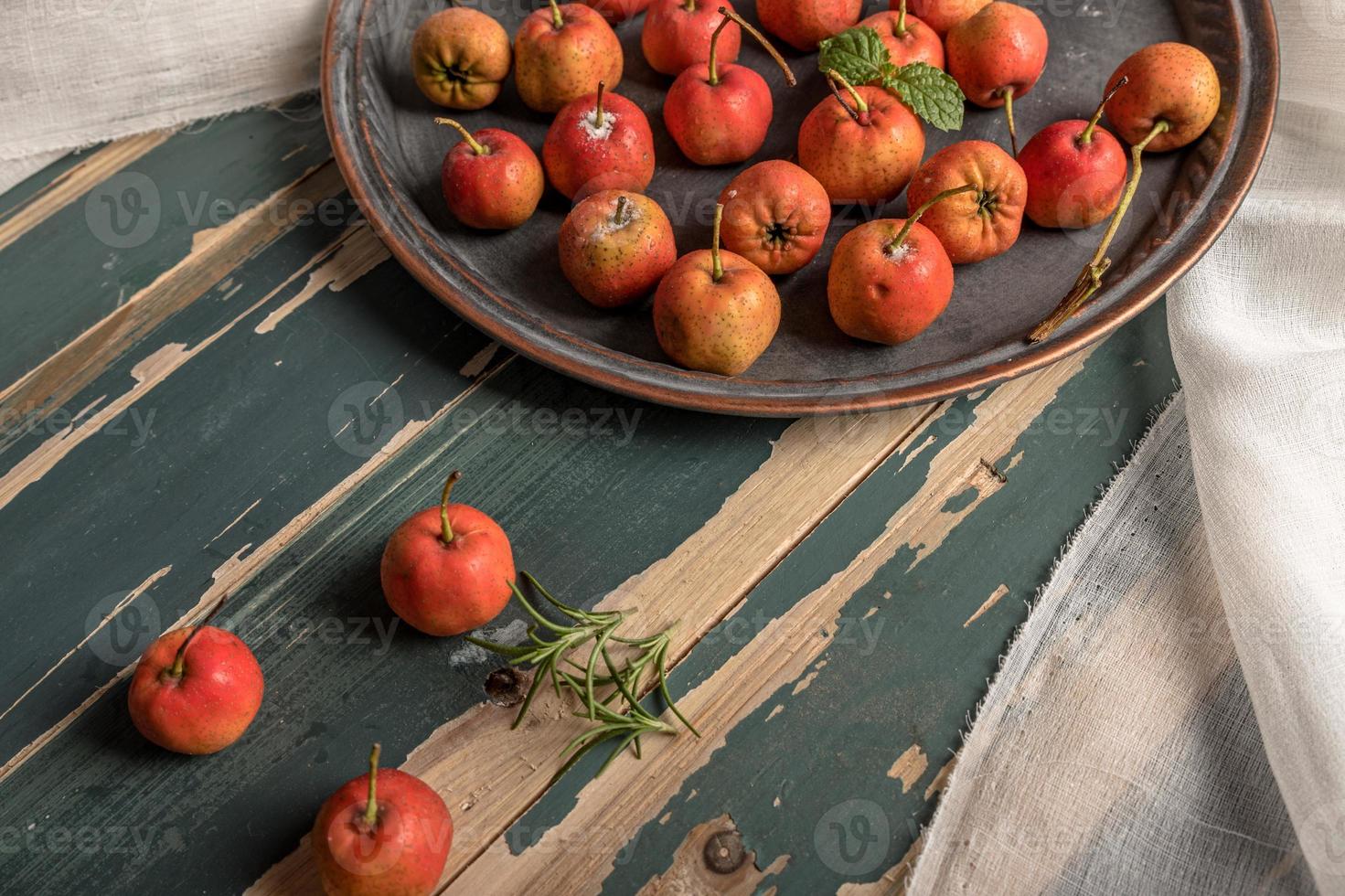 aubépine rouge sur une assiette ou éparpillée sur une table en bois photo