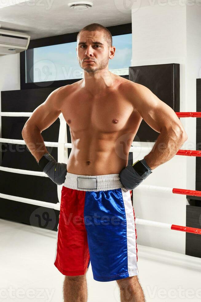 boxeur dans bleu gants chauffage en haut dans le Gym photo