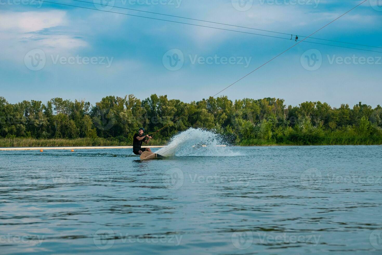 homme équitation wakeboard sur calme rivière sur été journée photo