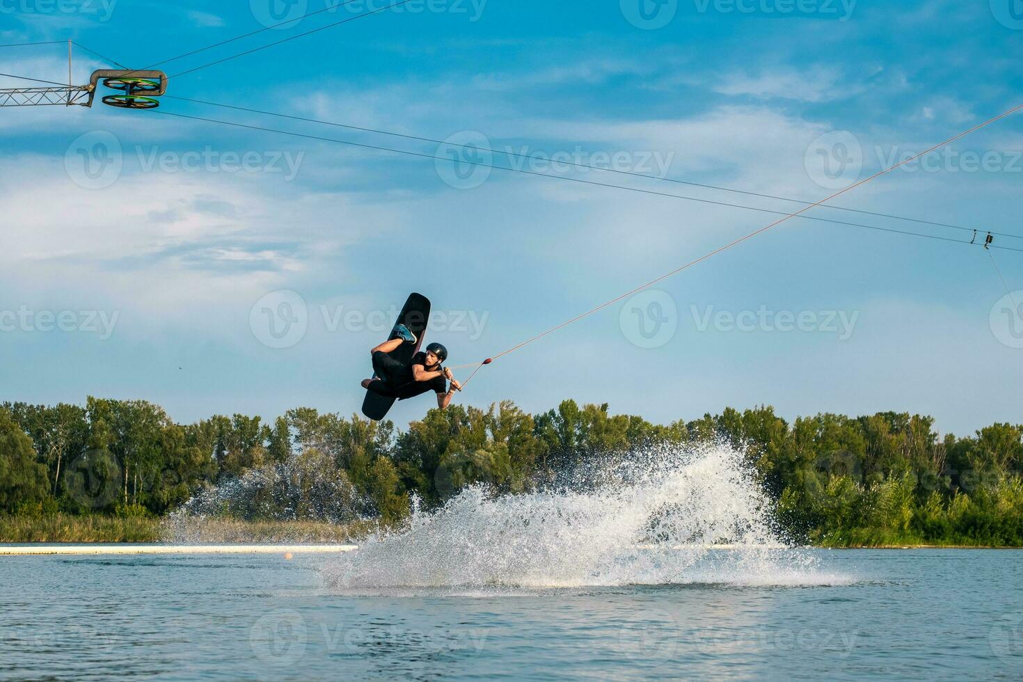 wakeboard cavalier remorqué sur câble sauter dans ouvert l'eau photo