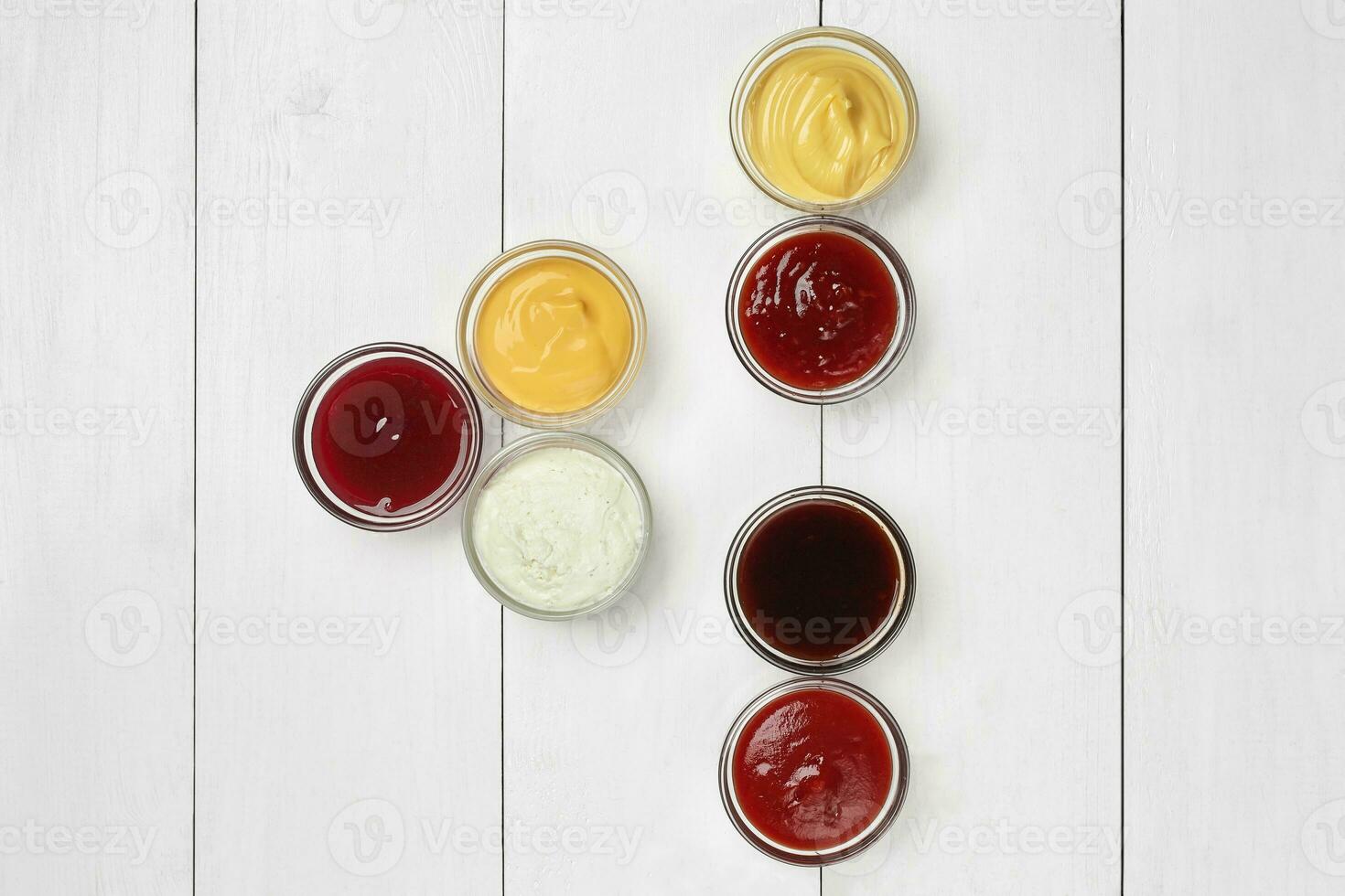 divers sauces dans verre plongement vaisselle sur blanc en bois table photo