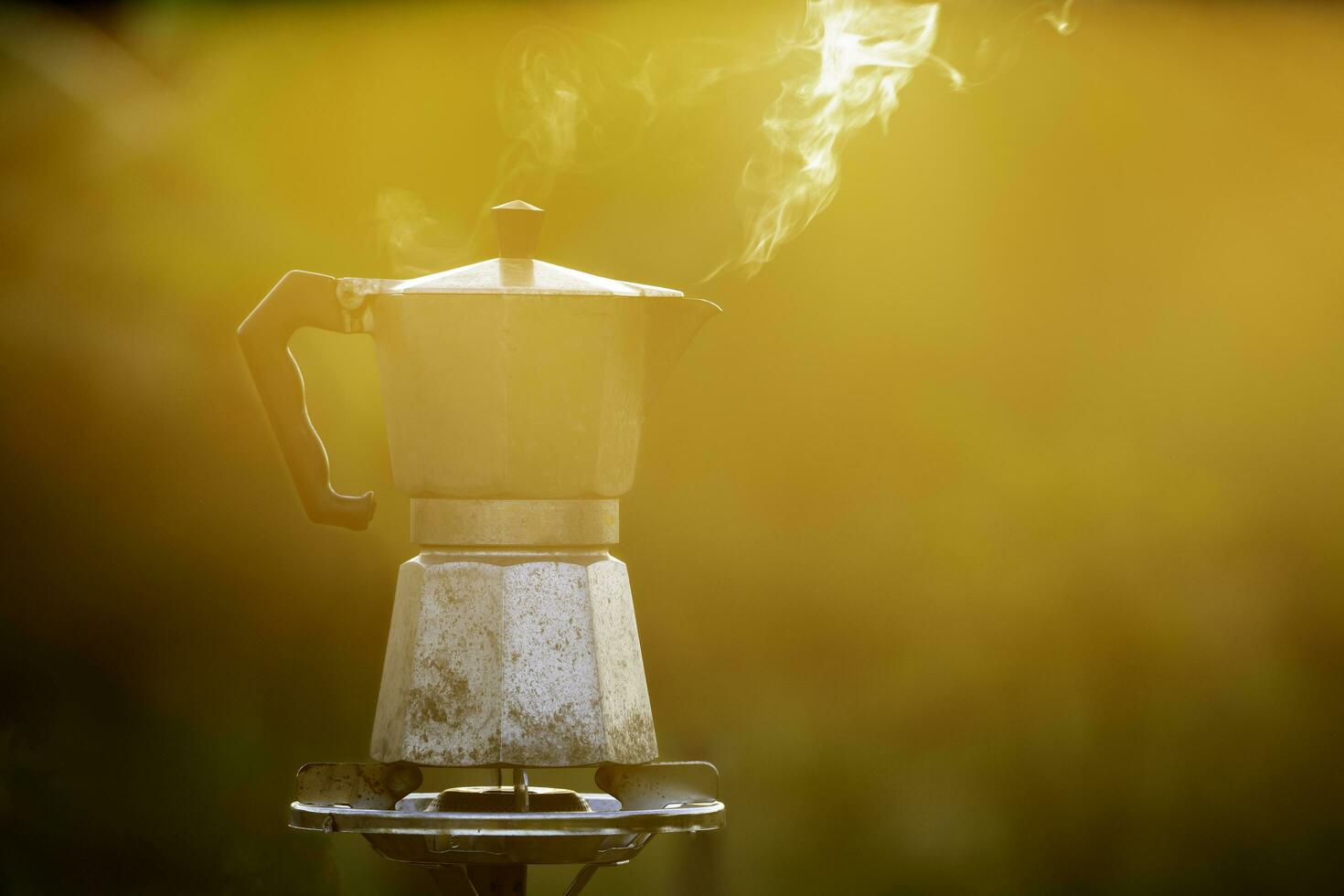 moka pot et fumée, vapeur de le café pot sur feu, dans le forêt à lever du soleil dans le Matin. doux se concentrer. peu profond concentrer effet. photo