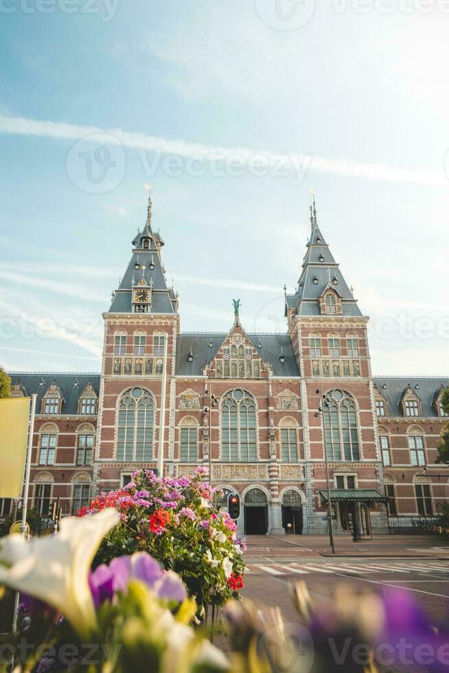 entrée à le rijksmuseum dans Amsterdam pendant lumière du jour heures dans le néerlandais capital. épanouissement fleurs autour le canal photo