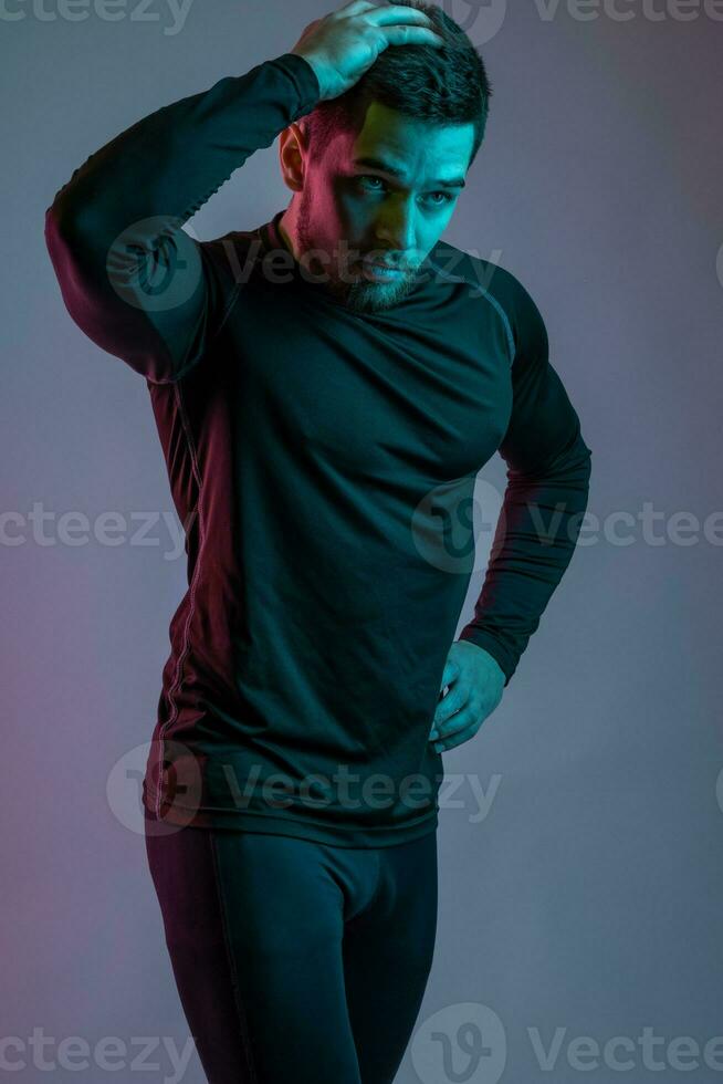 Jeune barbu athlète posant sur gris studio Contexte photo