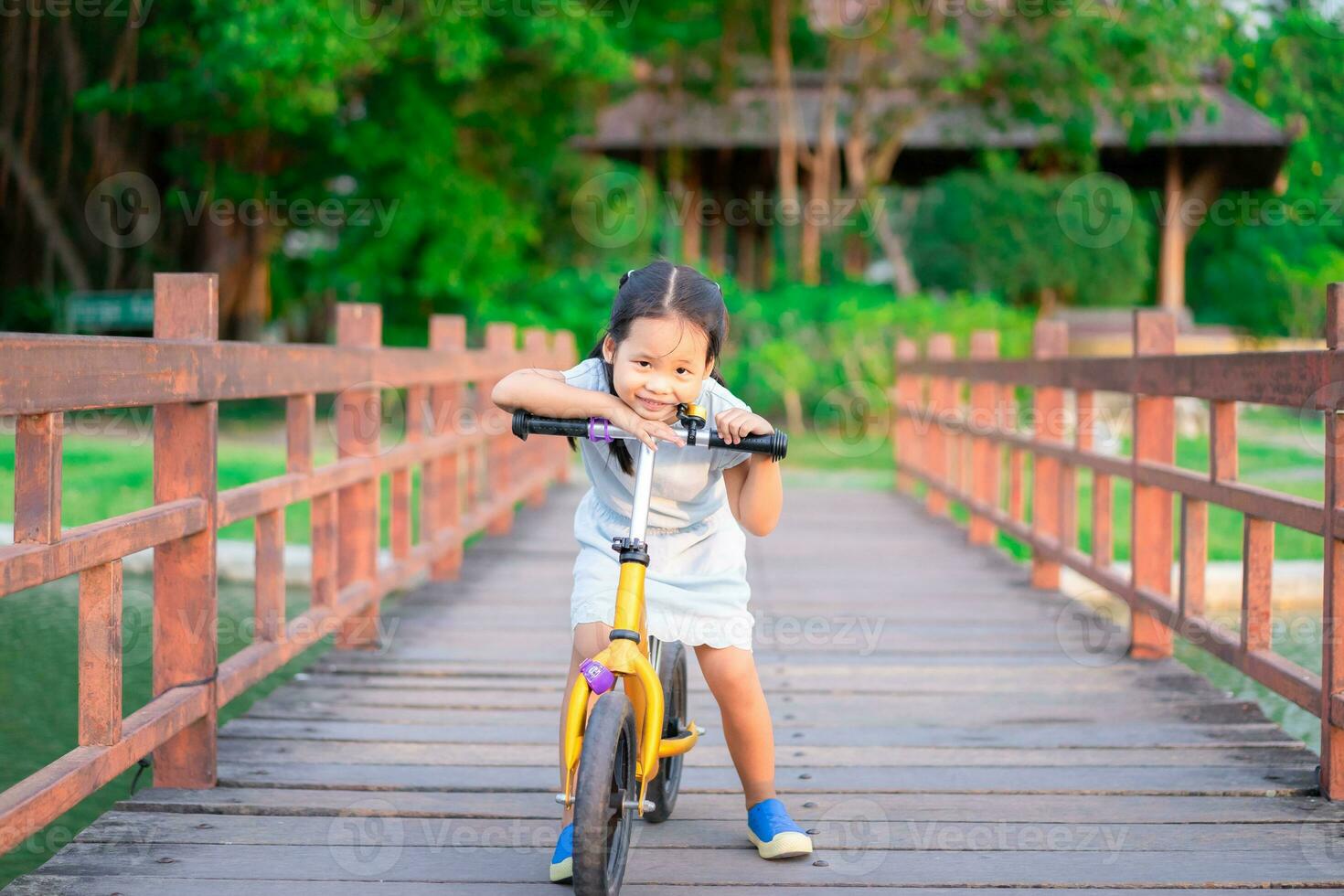 portrait de peu fille équitation équilibre bicyclette sur le pont photo