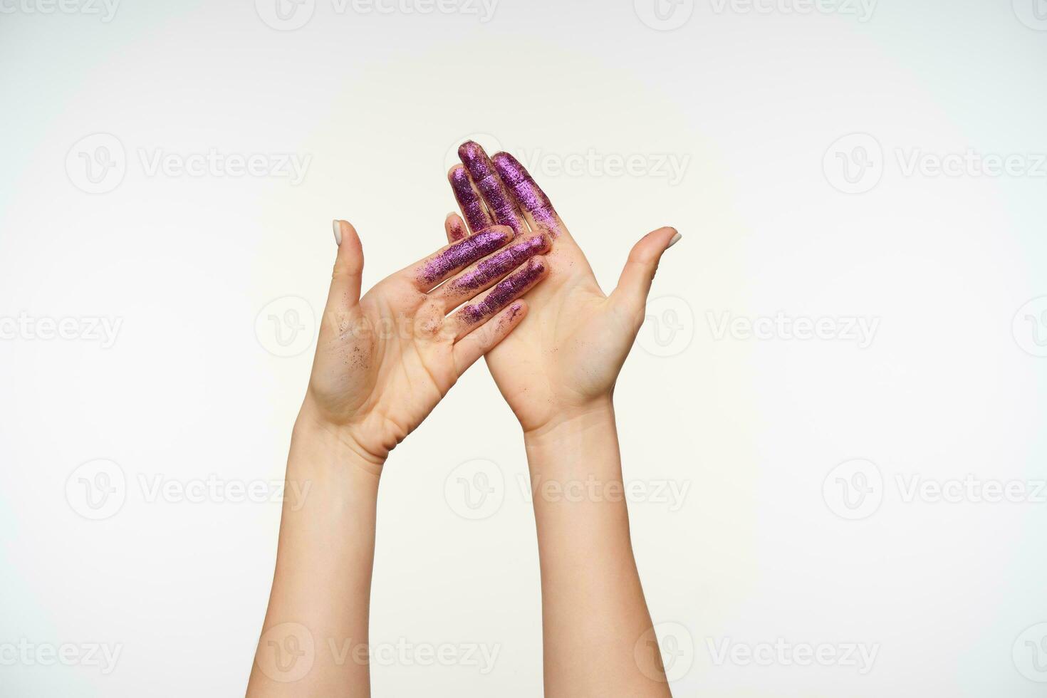 de face vue de Jeune peau claire jolie mains montrant paumes avec violet scintille tandis que posant permanent isolé plus de blanc Contexte. Humain mains et faire des gestes concept photo