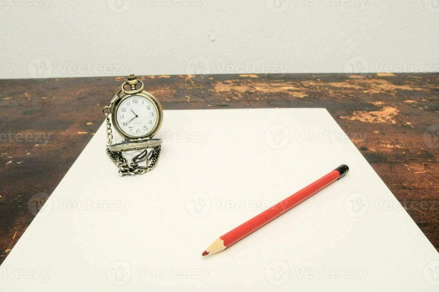 une poche regarder et crayon sur une table photo