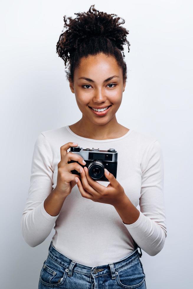 fille heureuse tient un appareil photo rétro dans sa main.