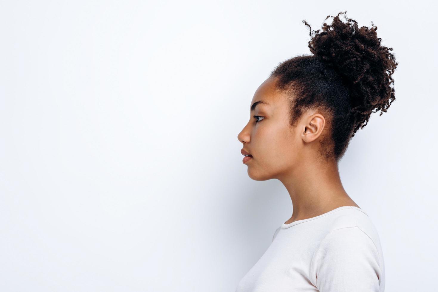 sur fond blanc, une fille afro-américaine se tient de profil photo