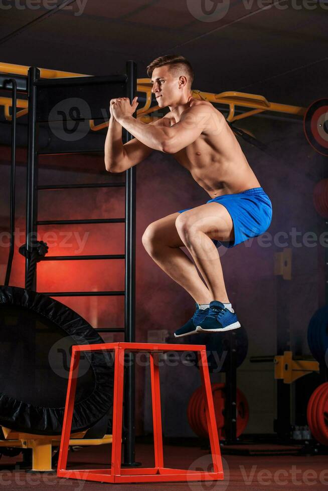 homme boîte sauter à une crossfit style salle de sport. photo