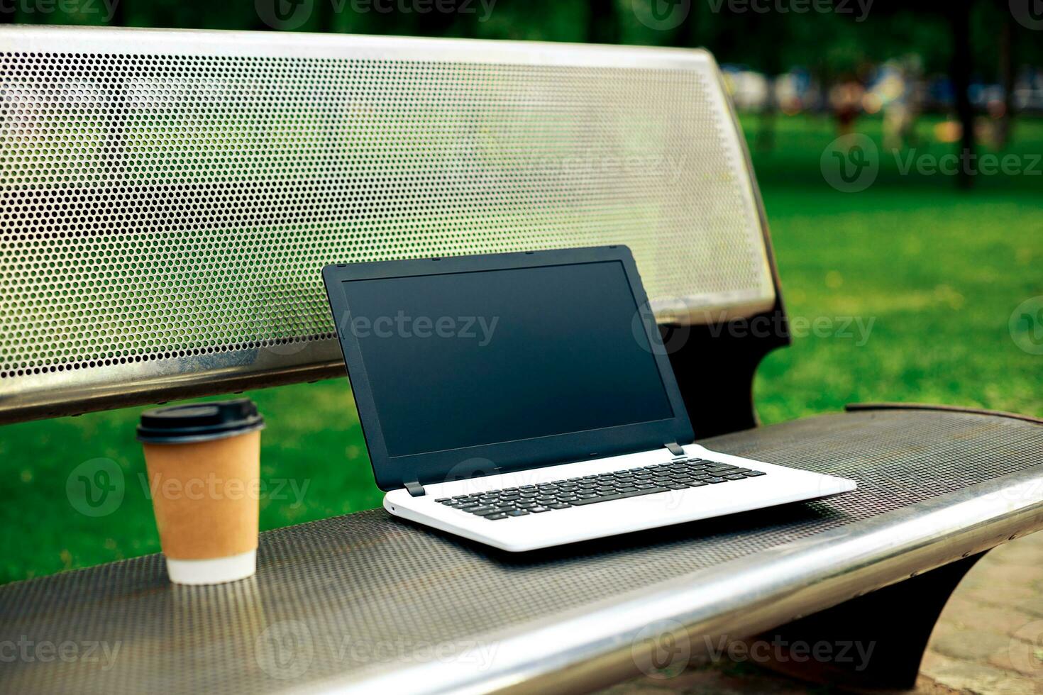 maquette image de portable avec Vide noir écran et café tasse sur métal banc dans la nature Extérieur parc photo