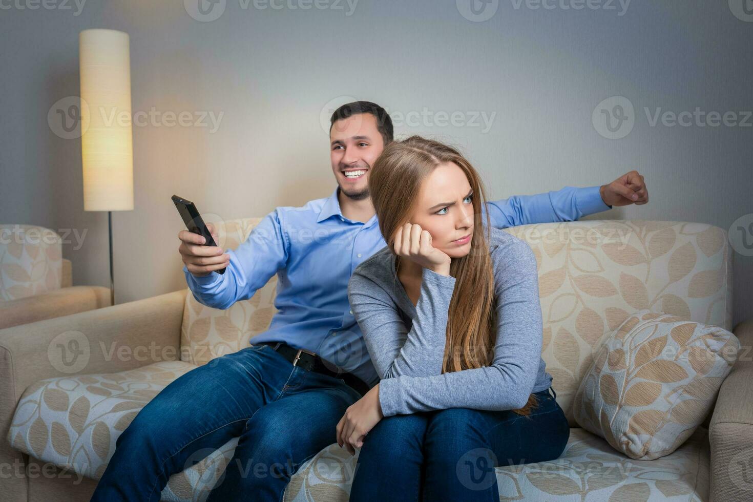 portrait de couple séance sur canapé en train de regarder télévision. photo