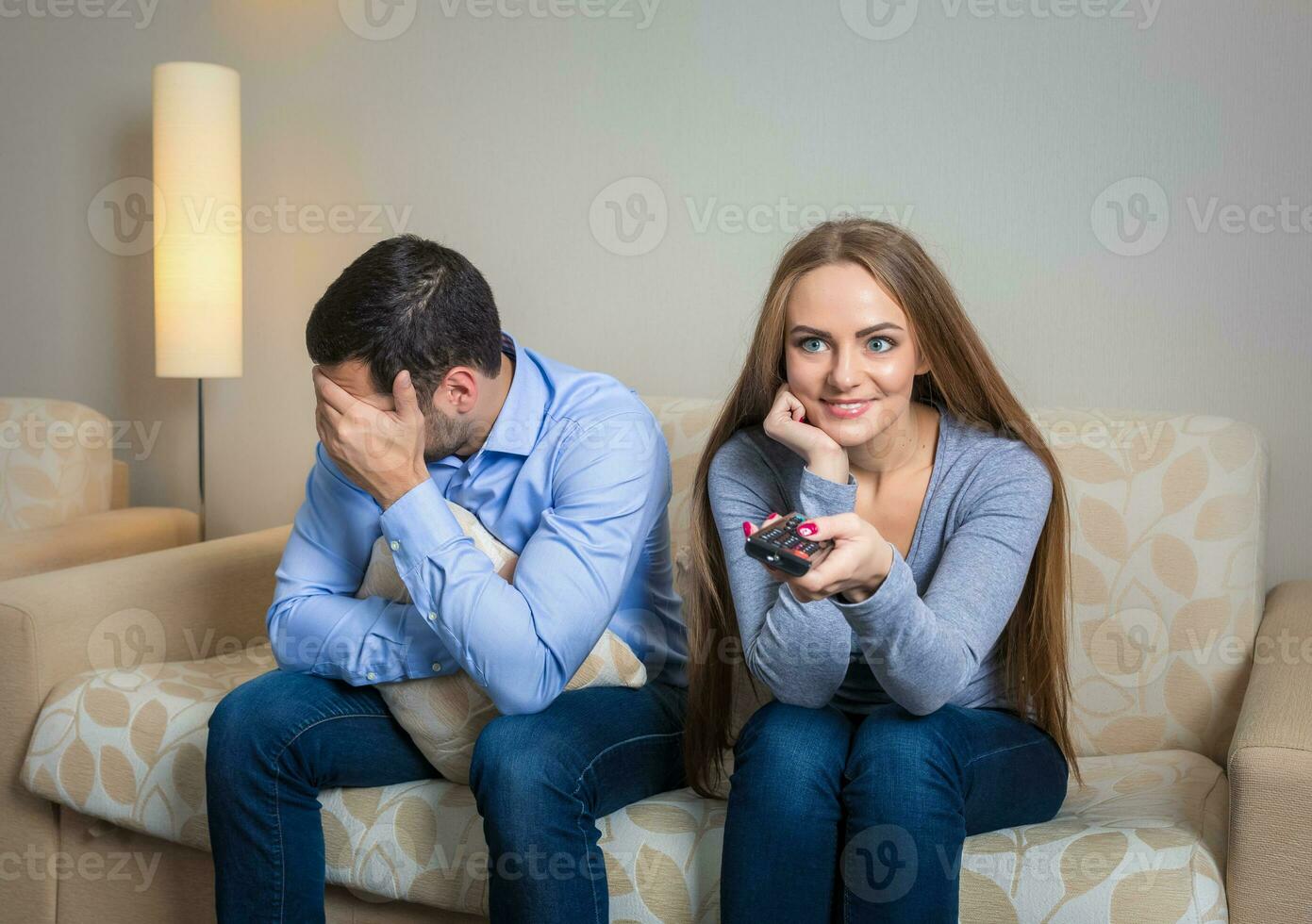 portrait de couple séance sur canapé en train de regarder télévision. photo