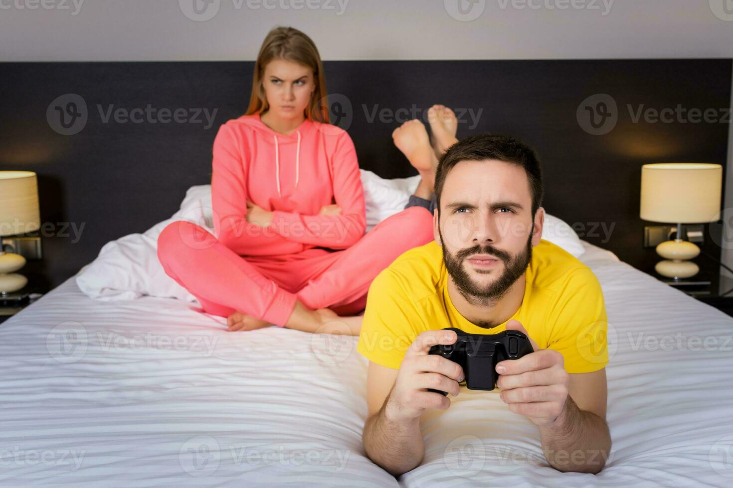 Jeune couple ayant en jouant jeux vidéos dans lit photo