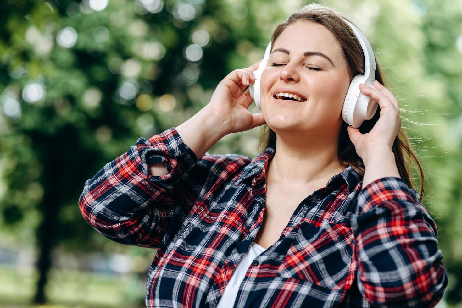 femme joyeuse dans des écouteurs sans fil chantant sa chanson préférée photo