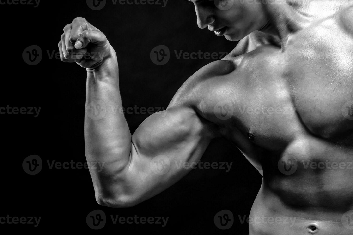 fermer de homme fléchissement montrant le sien triceps, biceps muscles photo