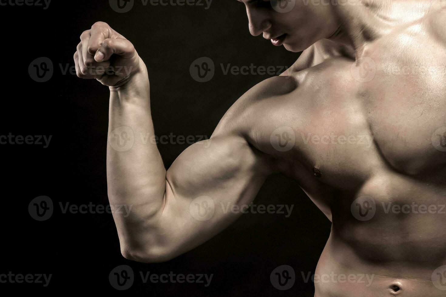 fermer de homme fléchissement montrant le sien triceps, biceps muscles photo
