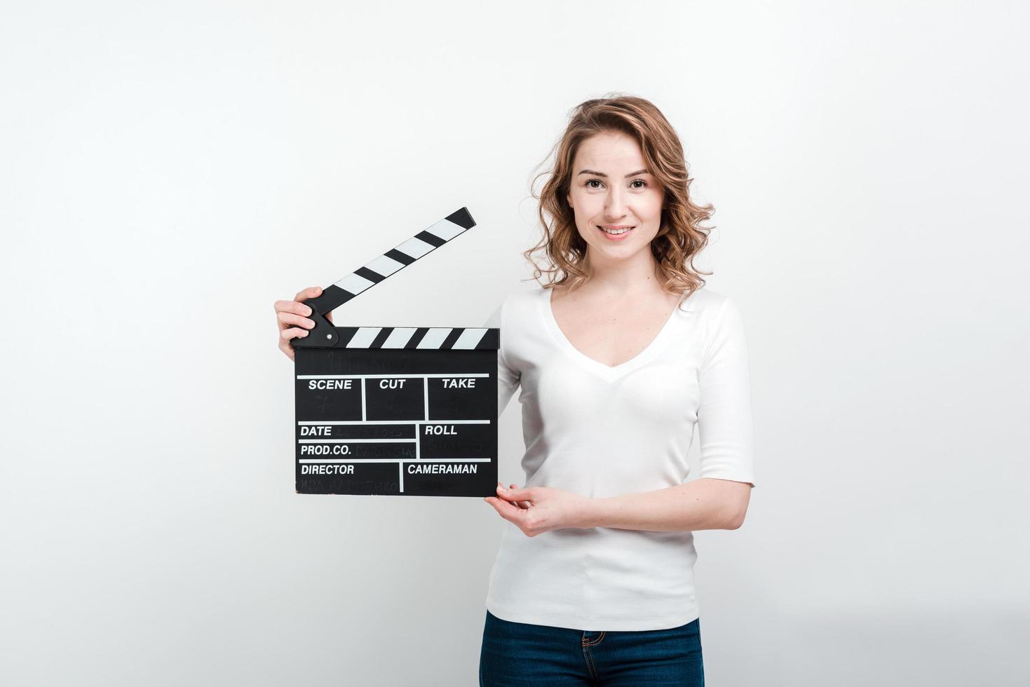 fille souriante tenant une planche de cinéma. photo