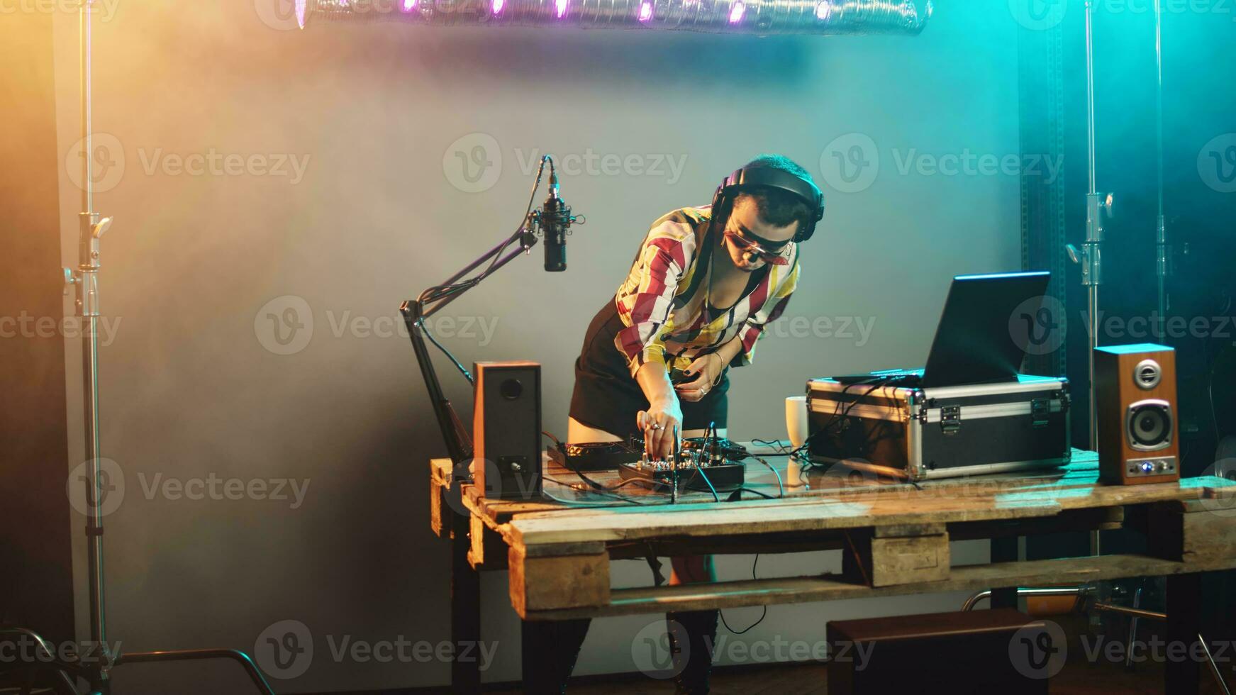 somnolent dj femme bâillement et en essayant à mélanger enregistrements à faire la fête, en buvant café à avoir certains énergie pour génial techno performance à boîte de nuit. artiste sentiment épuisé à stéréo platines. ordinateur de poche tir. photo