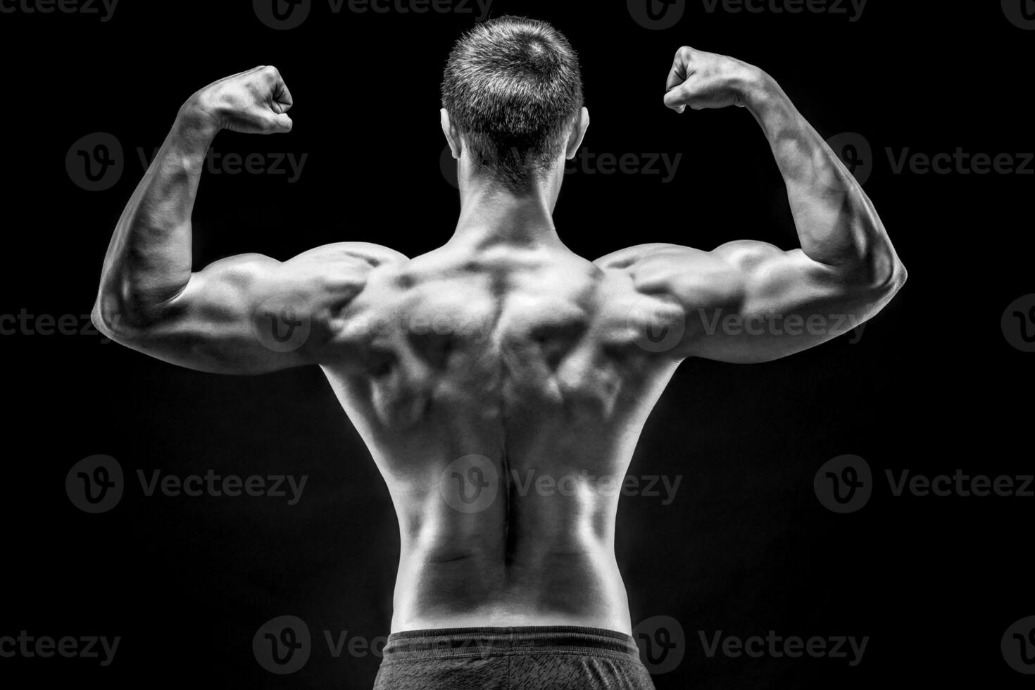 arrière vue de musclé Jeune homme montrant dos, biceps muscles photo