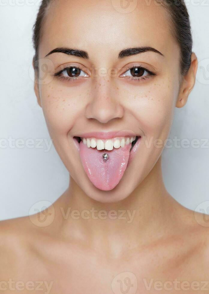 belle femme qui sort sa langue et montrant les jeunes piercing photo