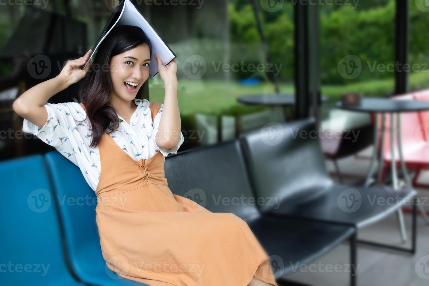 femmes asiatiques lisant et souriantes et heureuses de se détendre dans un café après avoir travaillé dans un bureau réussi. photo