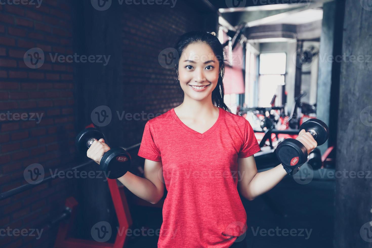 belle femme en forme musculaire exerçant des muscles de construction et femme de remise en forme faisant des exercices dans la salle de gym. remise en forme - concept de mode de vie sain photo