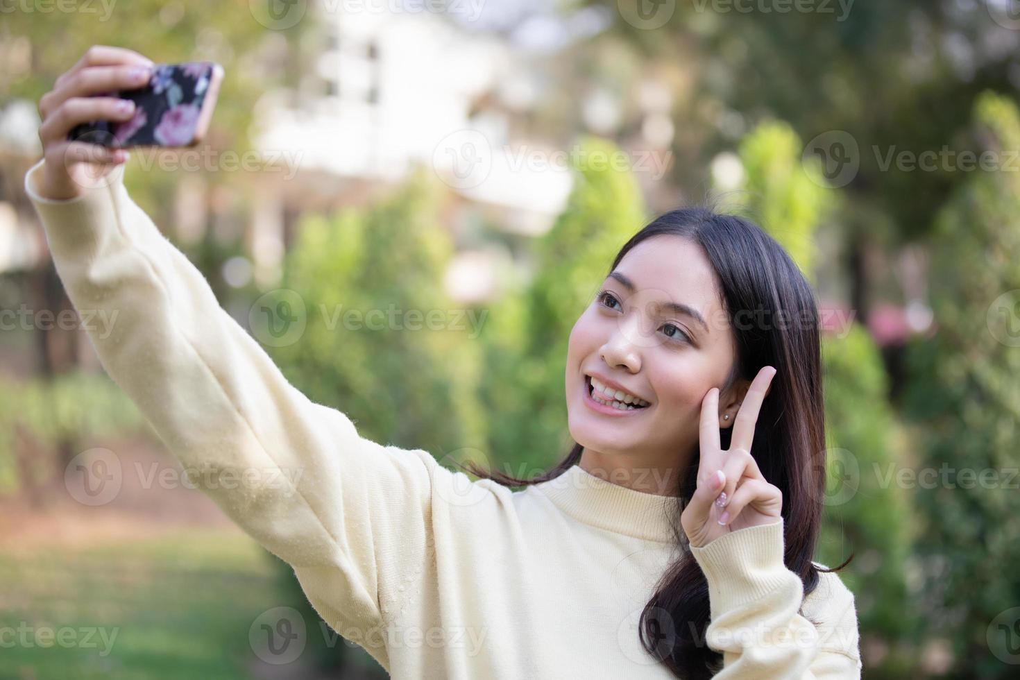 les femmes asiatiques souriantes prennent des photos et selfie